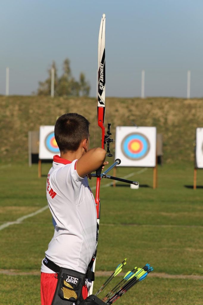 Teamleden spelen boogschieten in teamverband met zachte pijlen tijdens Archery Attack activiteit